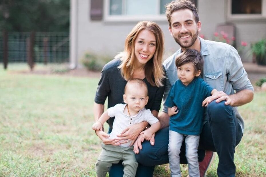 Danny Go and Mindy Mango with their two children, sitting on the grass outside their home.